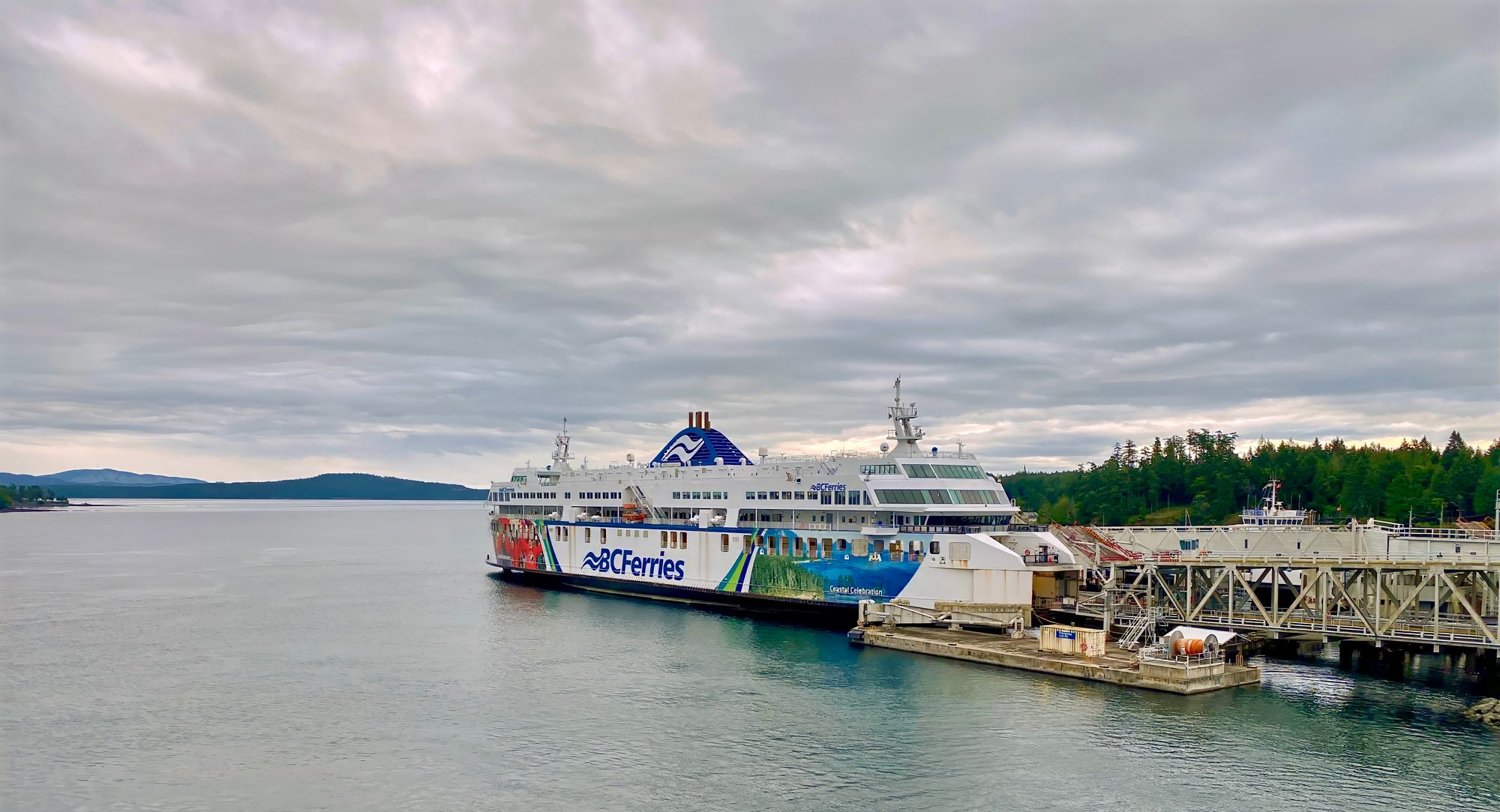 A medium-sized ferry with "BCFerries" written on the side sits at it's dock.